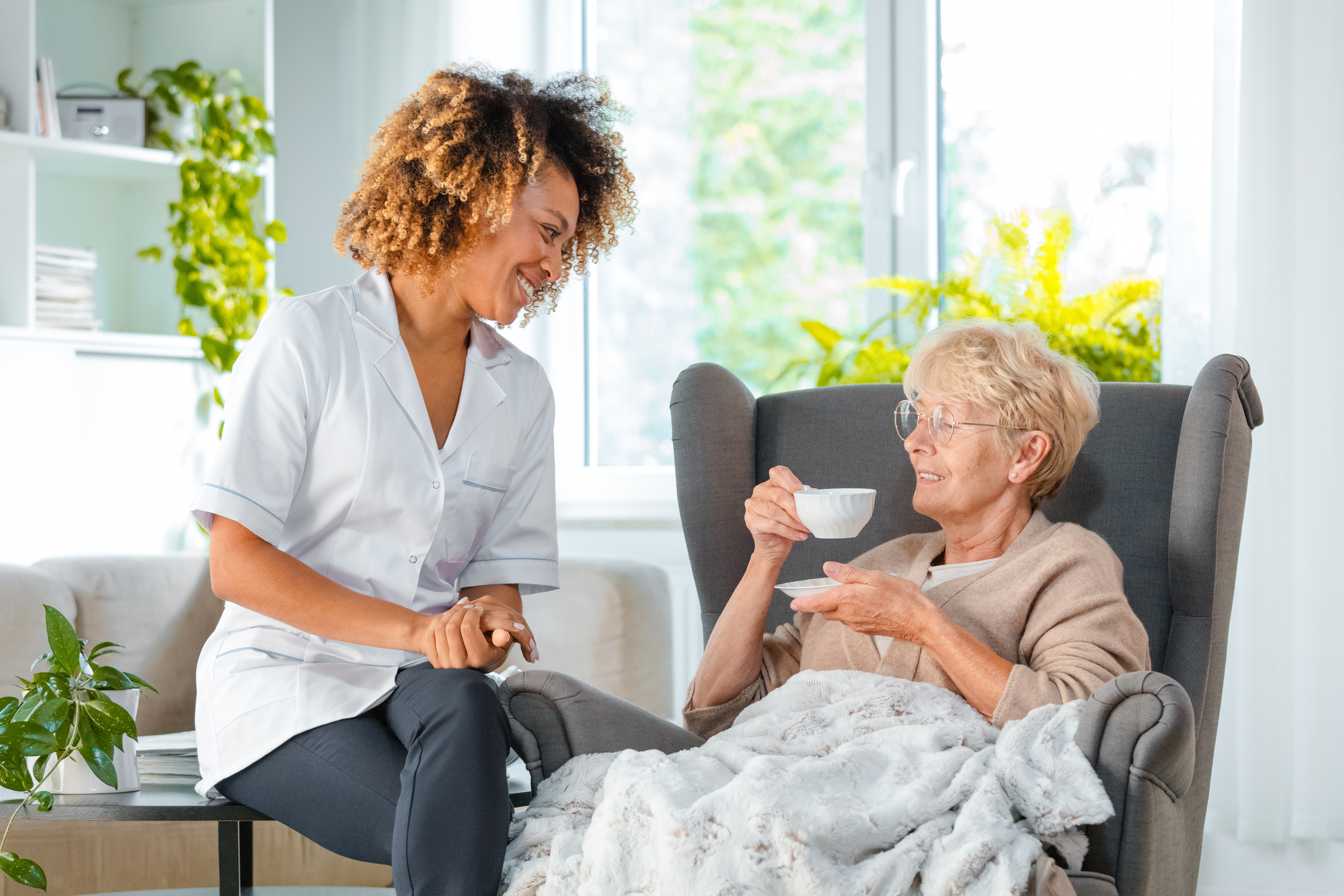 Cheerful nurse taking care of elderly lady